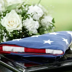 An American flag on a coffin with flowers
